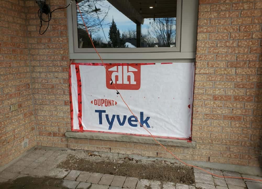 bricks removed from wall with Tyvek paper