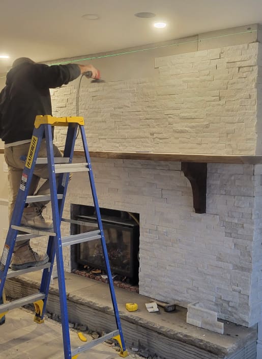 man installing fireplace veneers